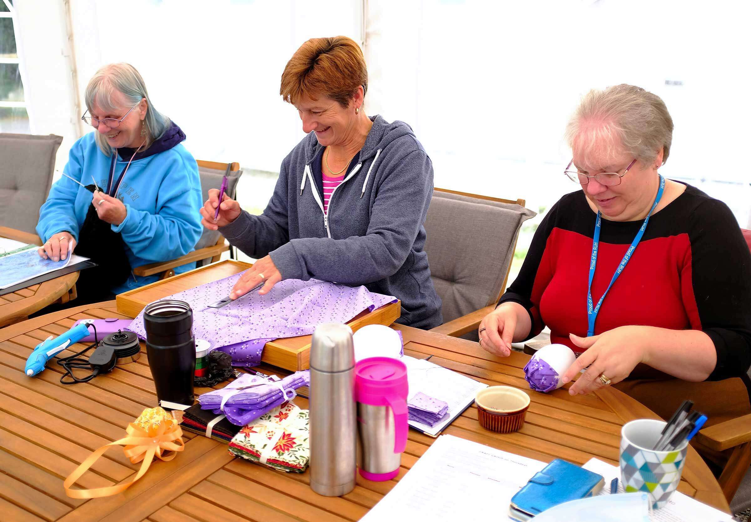 Women sat at a table doing crafts