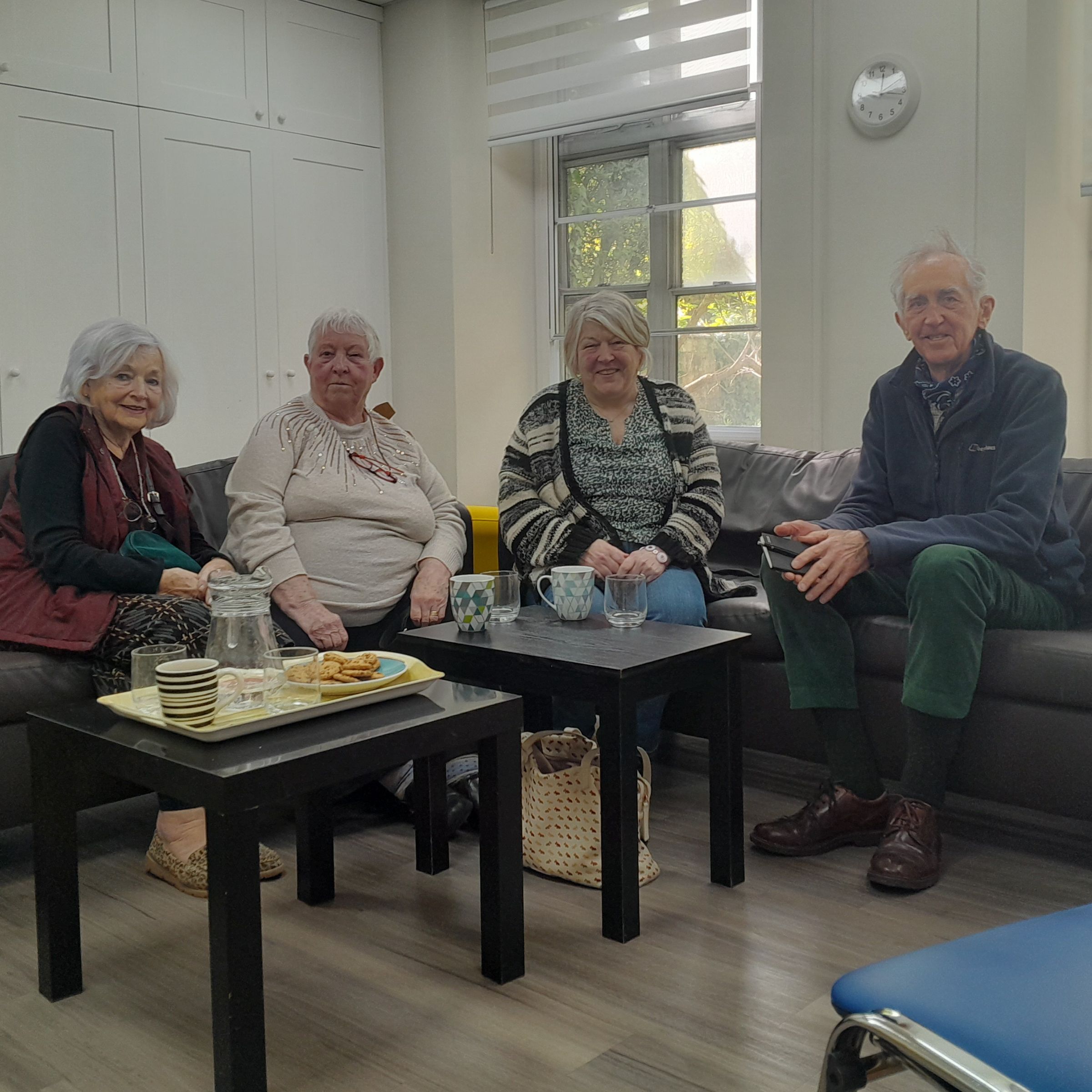 Image of four people sat on comfy chairs at the Headway Cafe