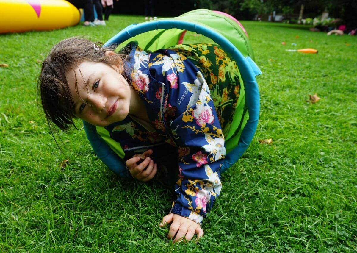 Child looking at the camera smiling coming out of a tube