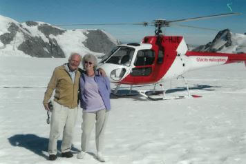Couple in the snow with a helicopter in the background