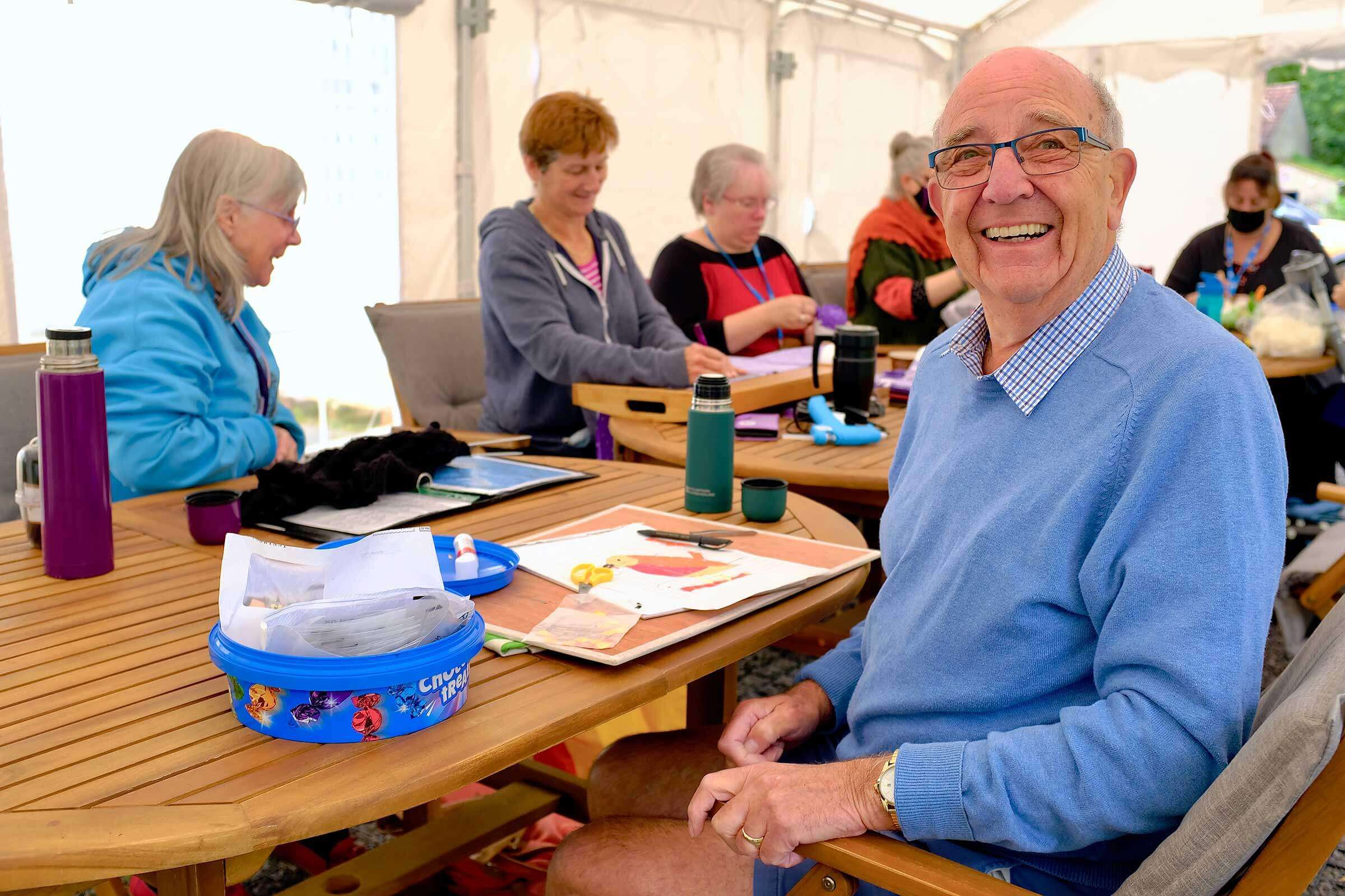 Man doing crafts looking at the camera smiling
