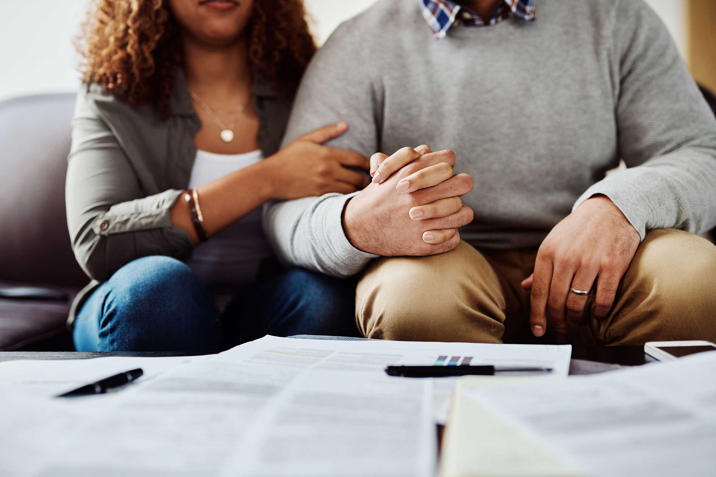 Man and woman sat together with them holding hands