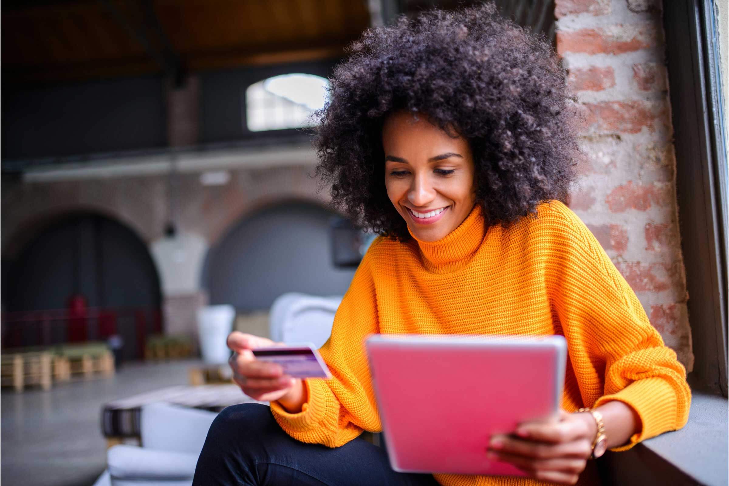 Woman Holding Payment Card and a tablet