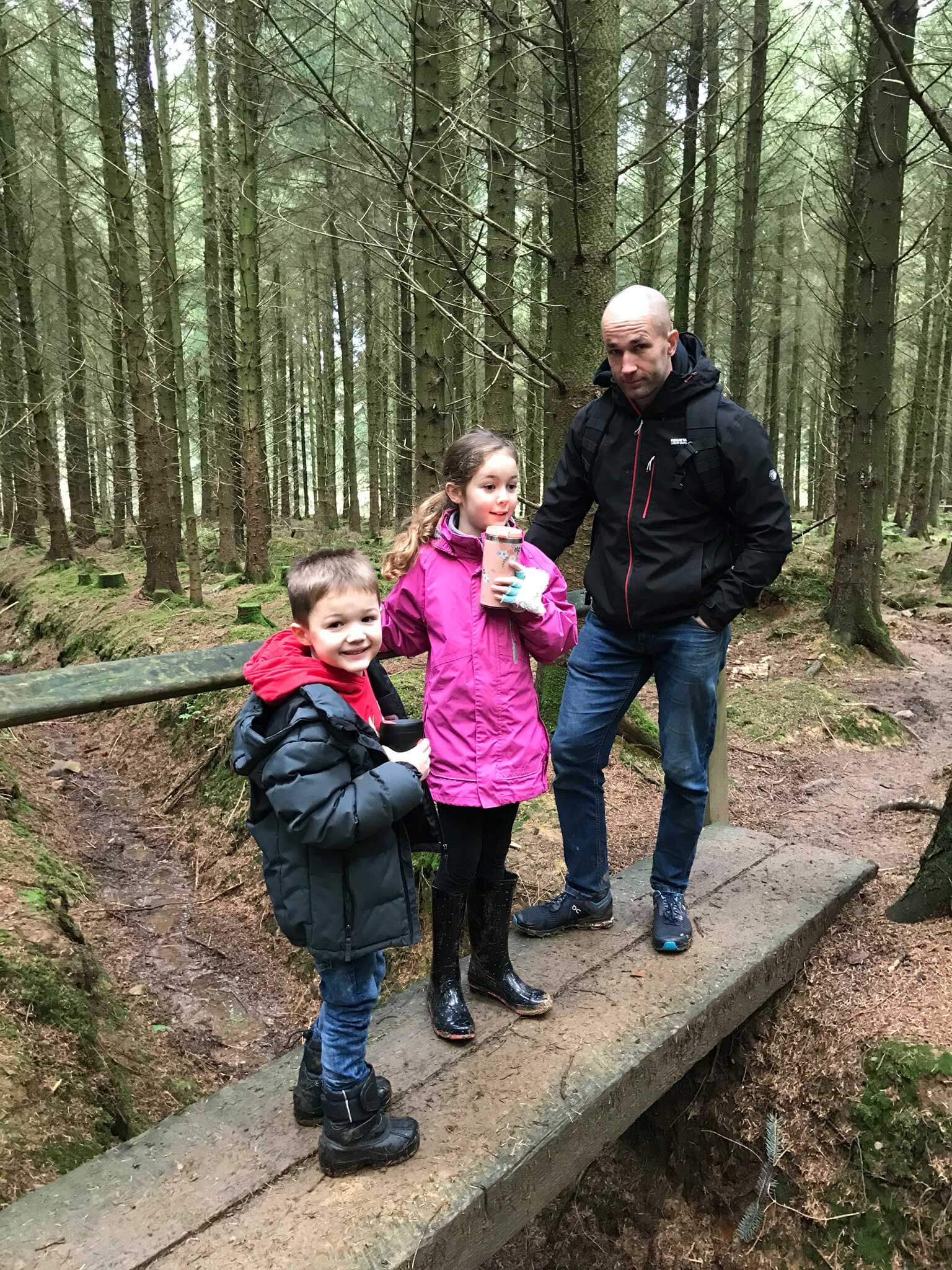Father with his two children, a boy and girl in the woods
