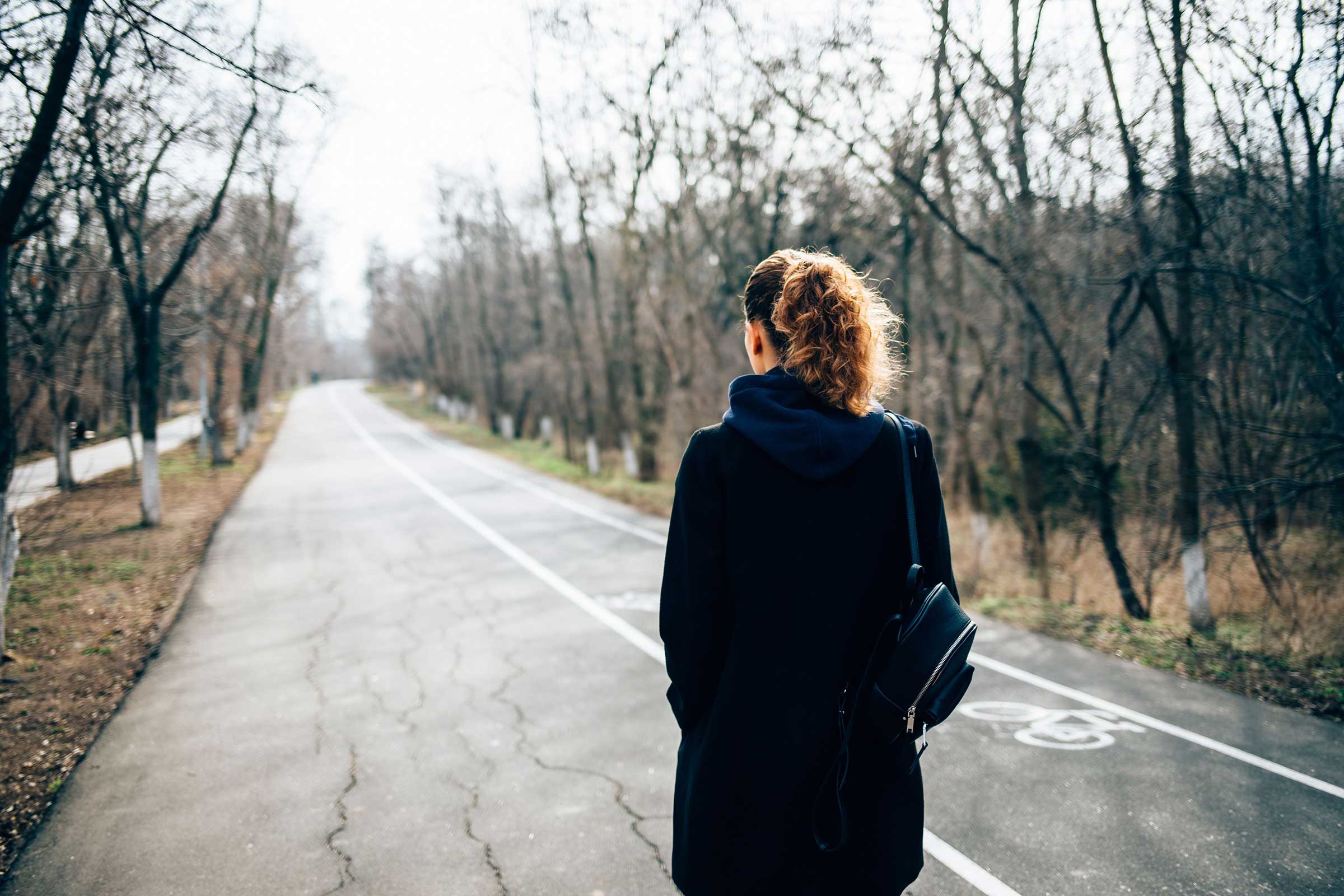 Woman walking down the road with her back to the camera