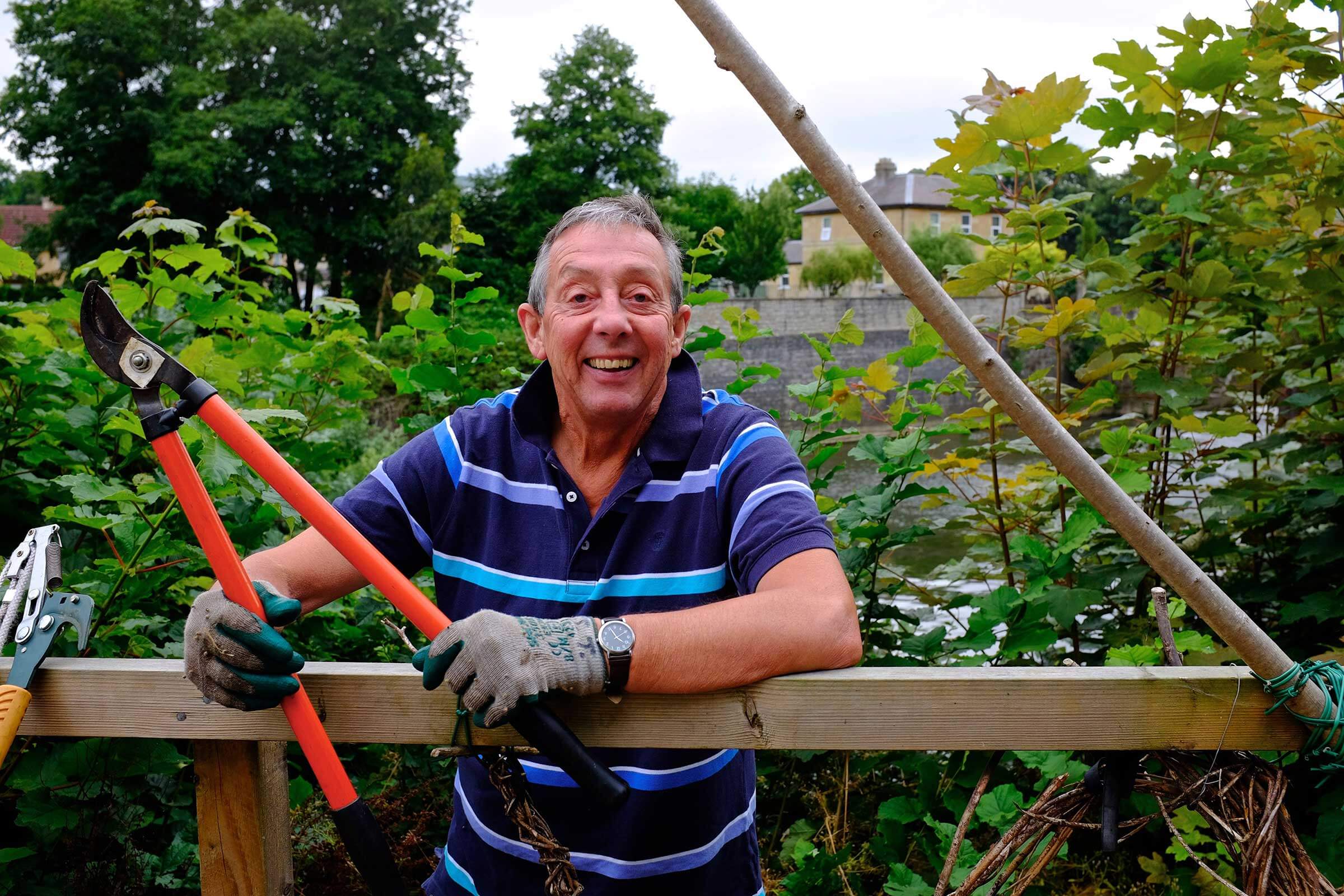 Man with shears volunteering with in the garden