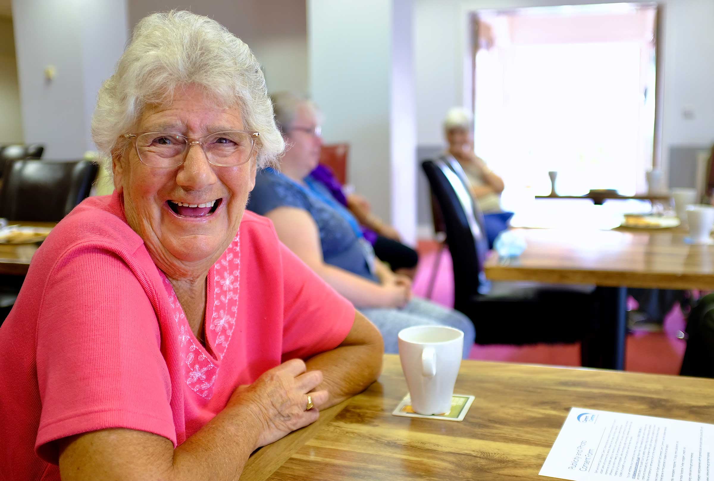 Woman at a table smiling at the camera