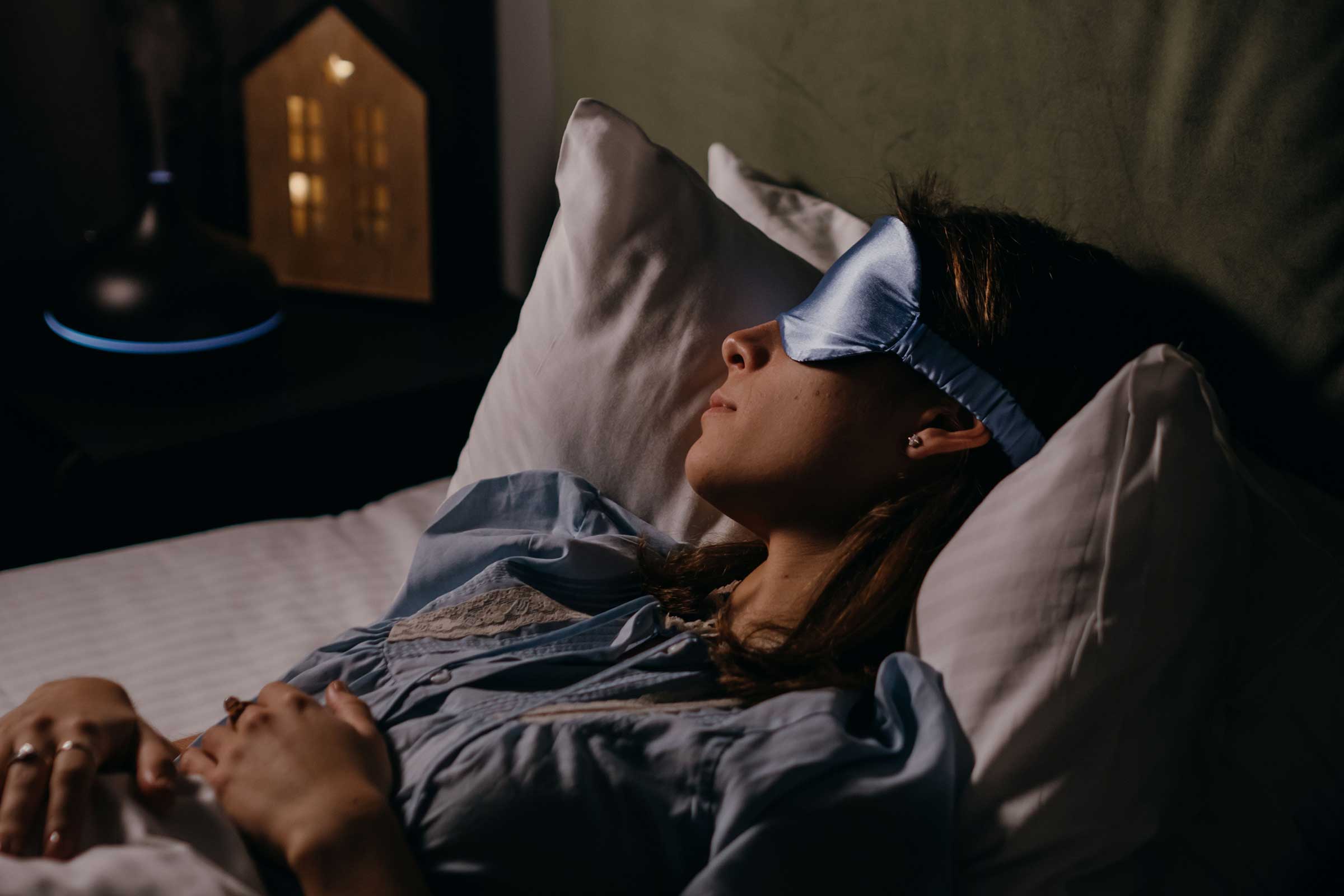 Women in bed asleep with a sleep mask on