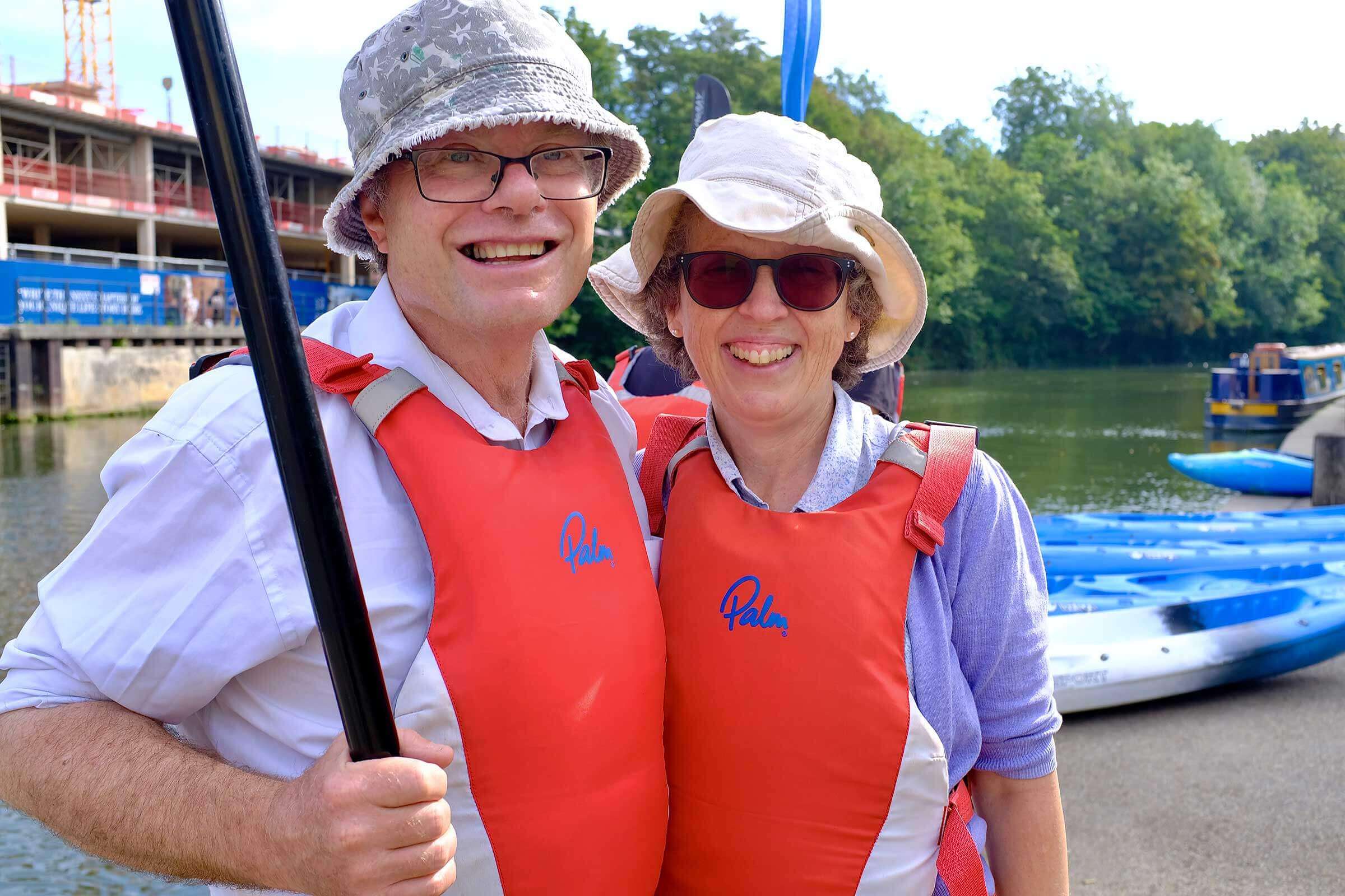 Man and woman with life jackets on smiling at the camera