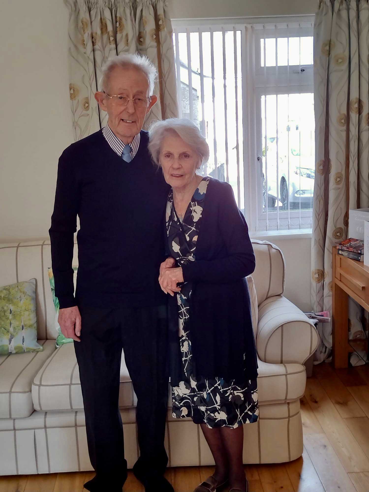 Older couple stood together in their living room
