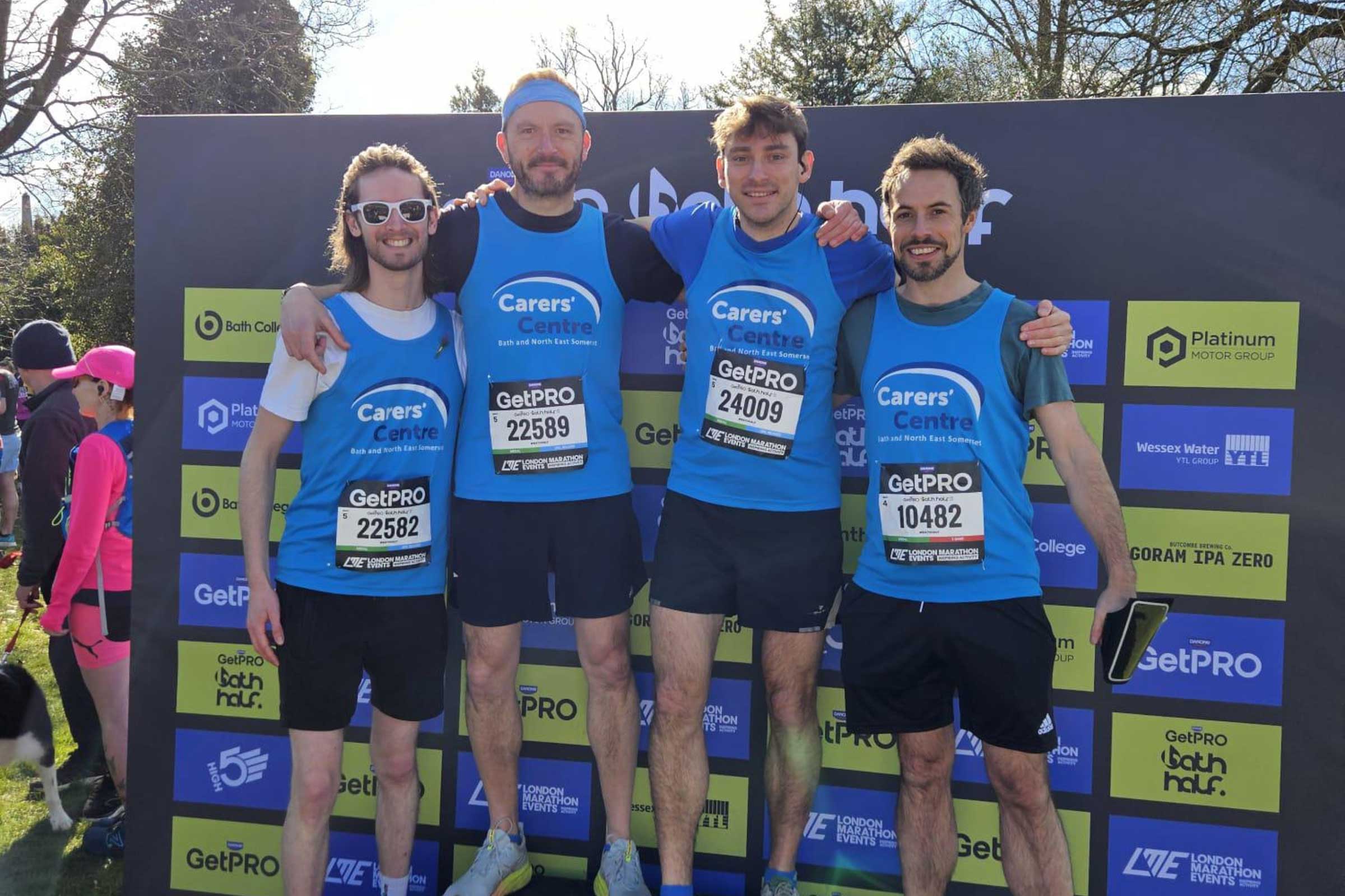 Group of men in Carer Center running vests smiling at the camera