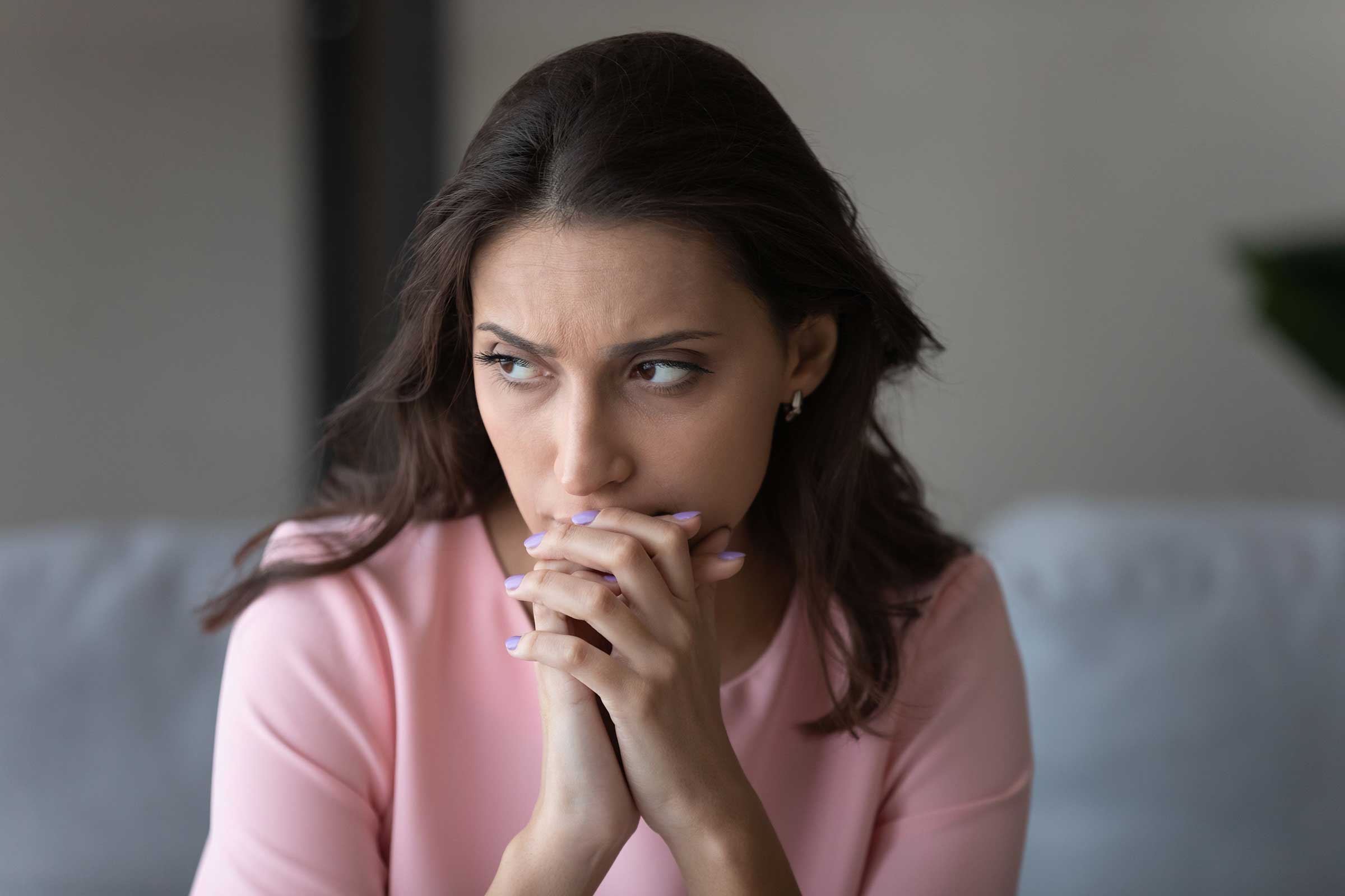 Women clasping hands looking worried