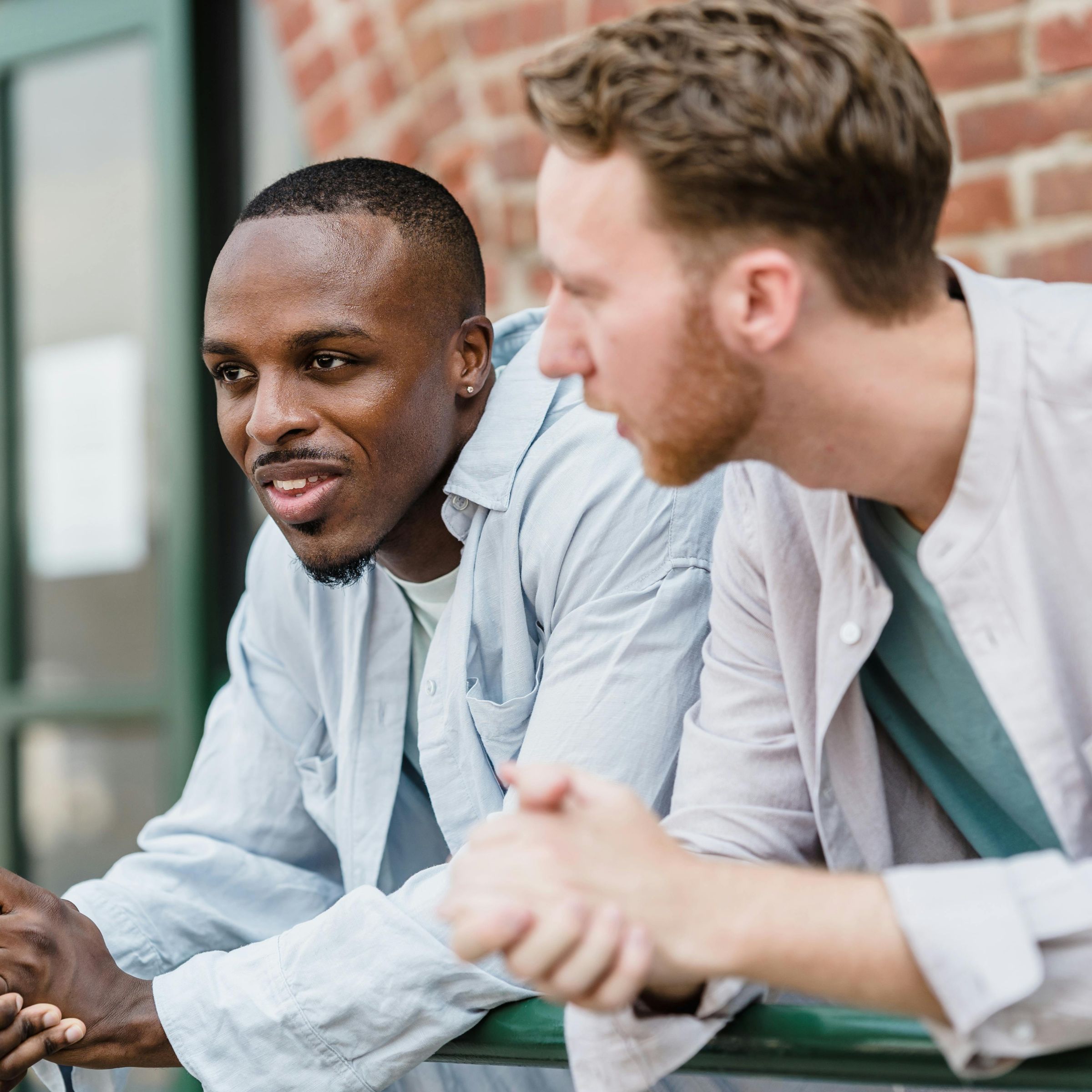 Two men looking forward and talking to each other