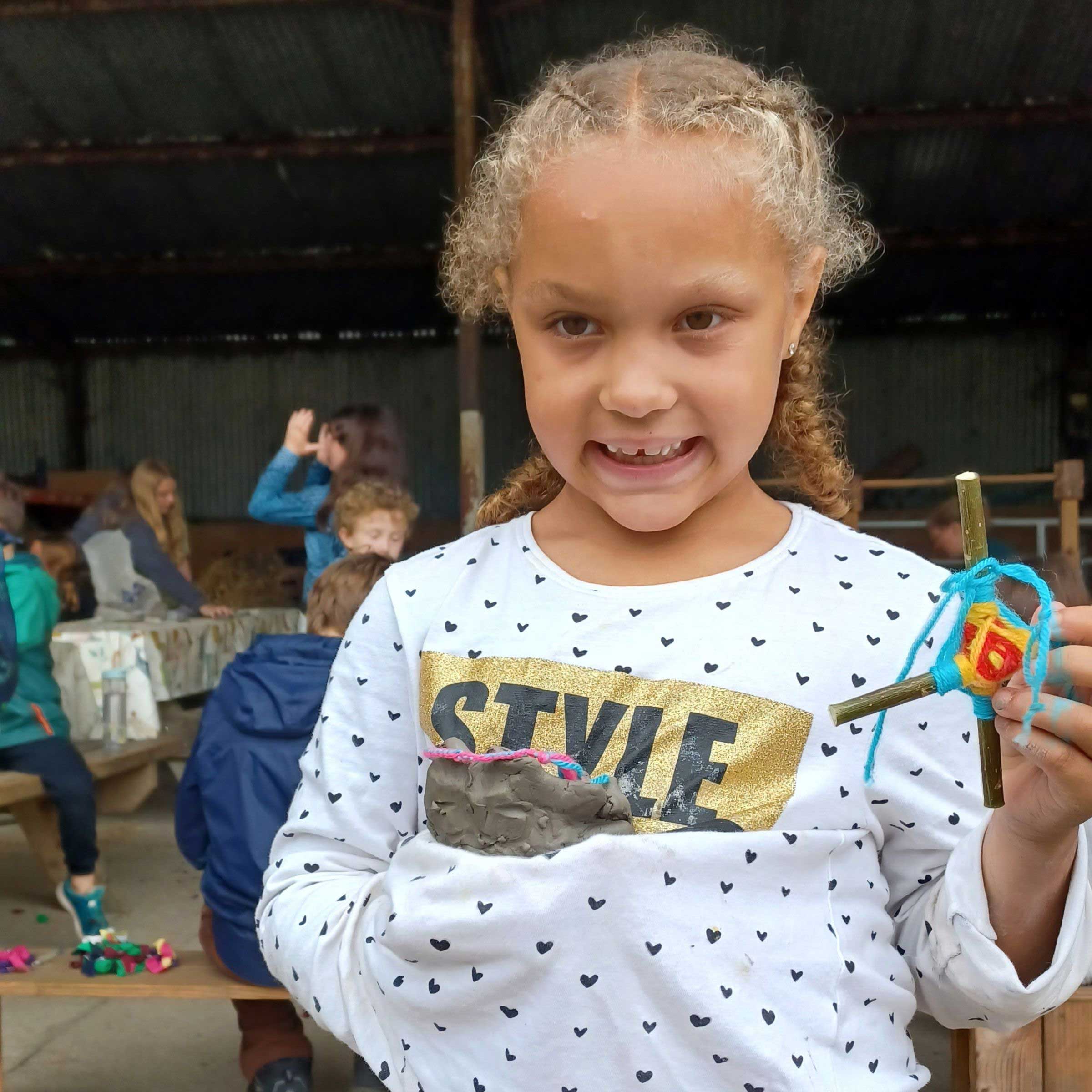 Young carer holding clay creation