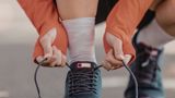 Person lacing up a running shoe