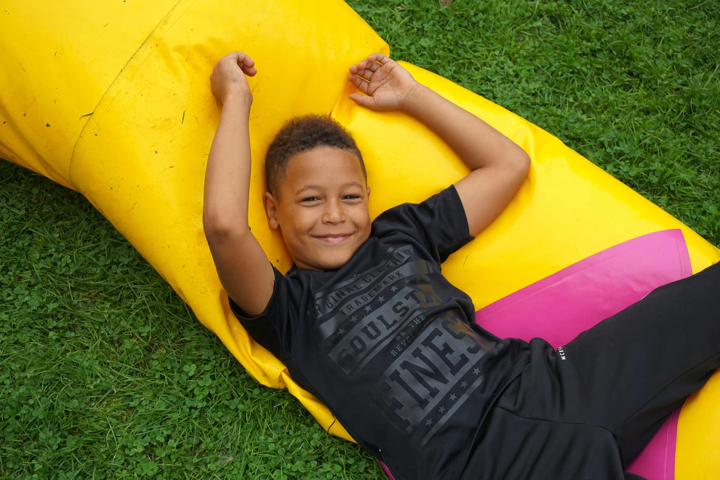 Boy laying on an inflatable smiling at the camera