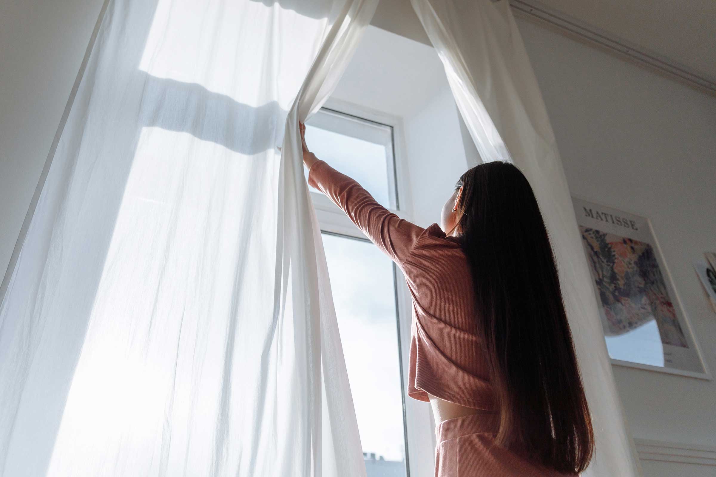 Woman open curtains